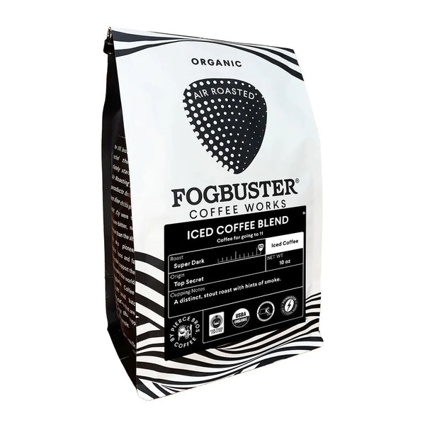 A white and black bag of Fogbuster® Coffee Works Iced Coffee Blend. The front label features roast info, icons, and tasting notes: "A distinct, super dark roast with hints of smoke." Ideal for those who love bold, smoky coffee.