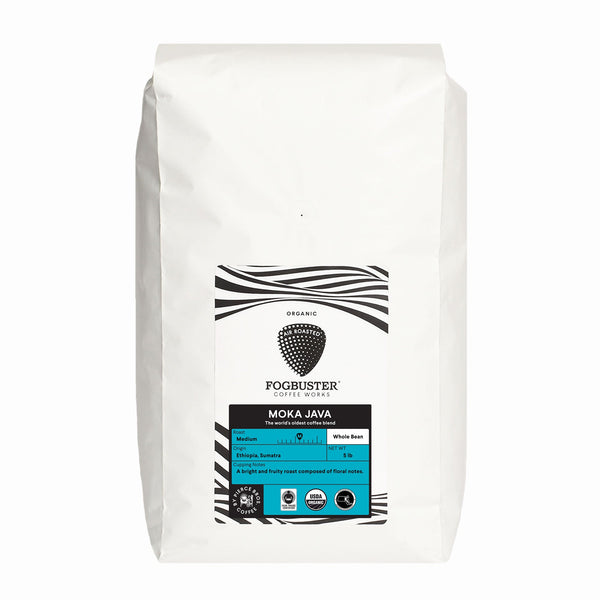 A white bag of Fogbuster® Coffee Works Moka Java whole bean coffee with a zebra-striped black and white label, featuring product details and fruity notes from its Ethiopian coffee blend.