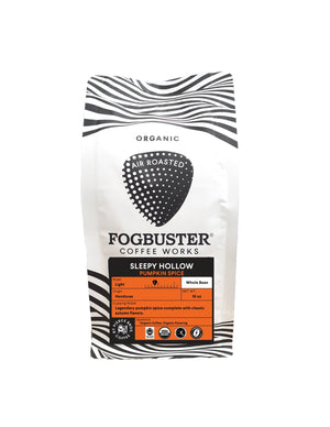 A bag of Fogbuster® Coffee Works Sleepy Hollow whole bean coffee comes in a white package with black zebra stripes and an orange label, highlighting its organic, light roast pumpkin spice flavor.