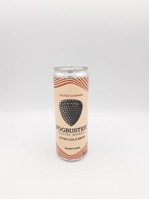 A can of Fogbuster® Coffee Works Salted Caramel Nitro Cold Brew stands upright on a plain white background, featuring a beige and orange design with a coffee bean graphic and the phrase "Shake Hard.