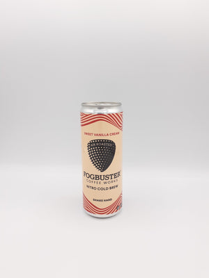 A shelf-stable can of Fogbuster® Coffee Works Sweet Vanilla Cream Nitro Cold Brew, featuring a beige and red striped design, stands upright on a plain white background.