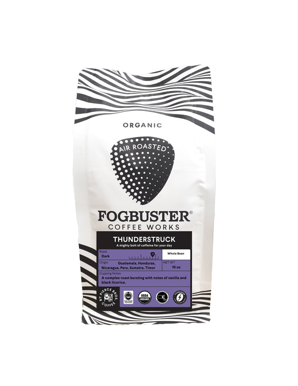 A bag of Fogbuster® Coffee Works' Thunderstruck French roast coffee. The packaging features a striking black and white zebra stripe design with a purple label that highlights its premium shade-grown, medium-dark roast origin from Guatemala, Honduras, Nicaragua, Peru, Sumatra, and Timor. Ideal for a caffeine boost.